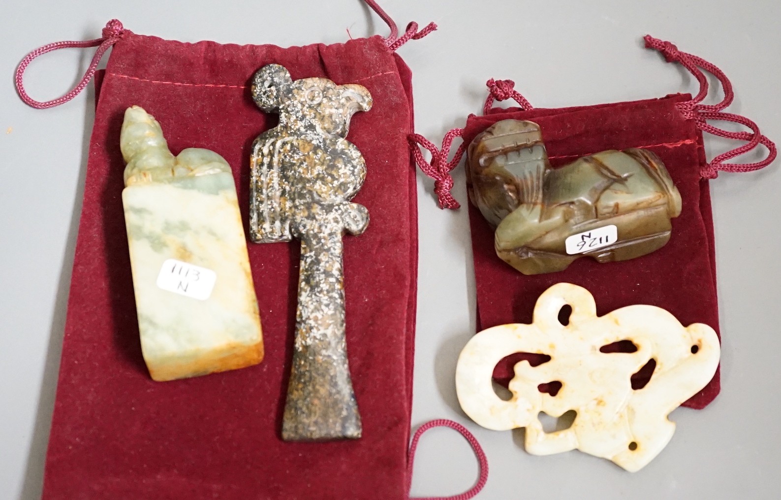 Four jade items: a mythical beast, a seal, a ritual image and a dragon
